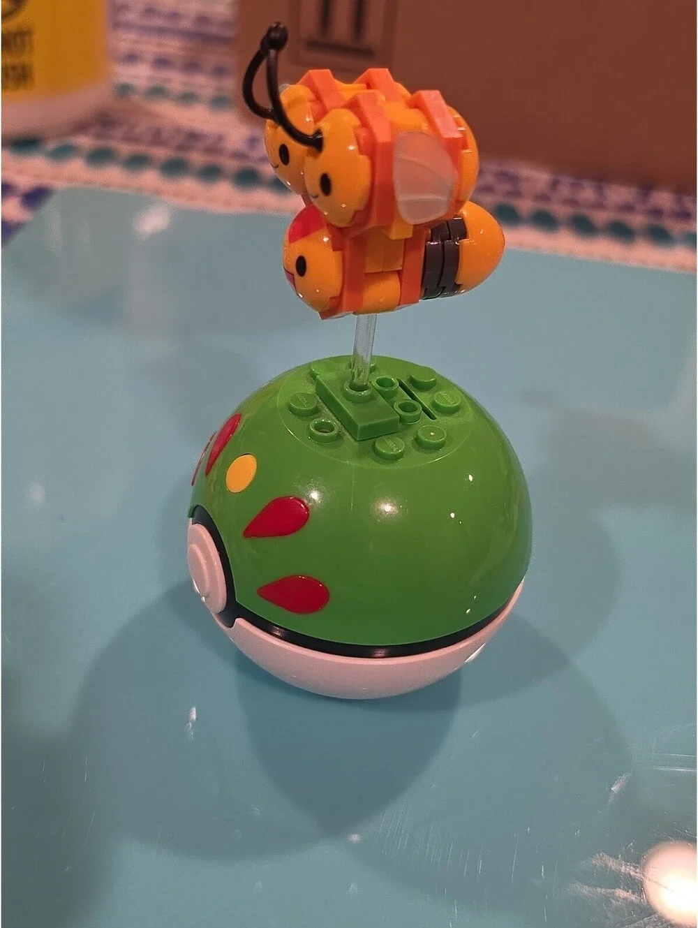 Pokémon Combee Plastic Figure on Green Poké Ball Base, Yellow/Black/Orange